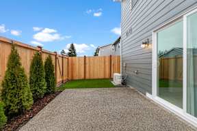 A backyard with a wooden fence and a green lawn.