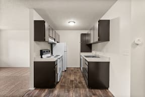 an empty kitchen with white appliances and black cabinets