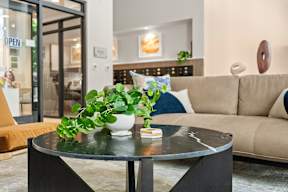 a living room with a couch and a table with a potted plant at Hue Apartments, Redmond