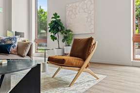 a living room with a brown chair and a table at Hue Apartments, Redmond , Washington