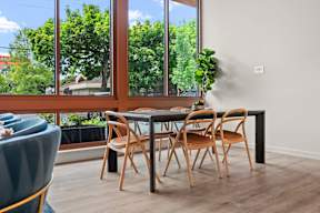 a dining room with a table and chairs and a large window at Hue Apartments, Redmond