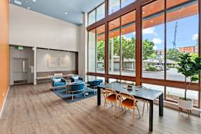 a dining area with a table and chairs and large windows at Hue Apartments, Washington, 98052