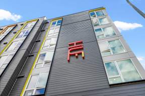 the red chair on the side of a building at Hue Apartments, Redmond , Washington