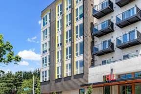 a tall apartment building with balconies on the side of it at Hue Apartments, Redmond , WA 98052