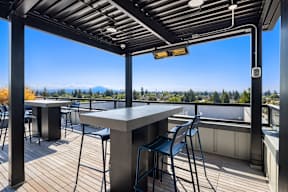A patio with a table and chairs overlooking a mountain range.