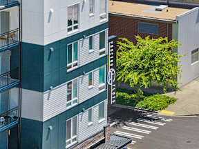 A tree is in front of a building with a sign that says "Prologis".