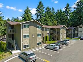 an apartment building with cars parked in a parking lot