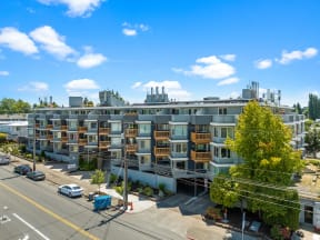a large apartment building with many balconies and a street in front of it