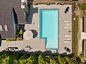 an aerial view of a swimming pool in a backyard with umbrellas
