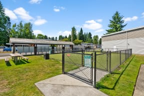 a fenced in area with a picnic table in front of a building
