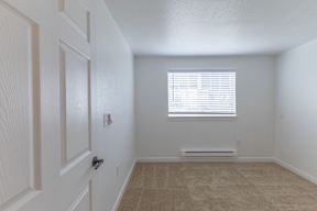 A room with a door, window, and carpeted floor.