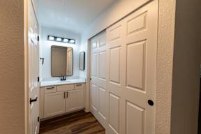 A white bathroom with a sink and mirror.