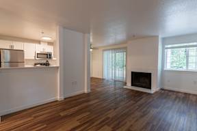 A spacious living room with a fireplace and hardwood floors.