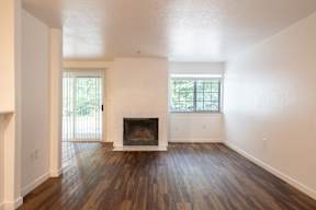 A room with a fireplace and wood flooring.