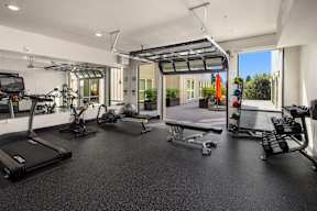 A spacious gym with treadmills, exercise bikes, and other equipment.