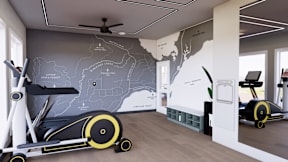 A room with a wall map of the United States and two stationary exercise bikes.