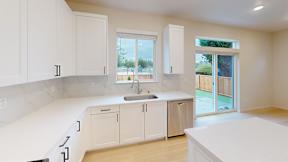 a white kitchen with a sink and white cabinets