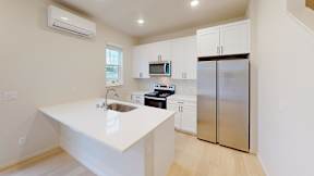 a white kitchen with stainless steel appliances and white counter tops