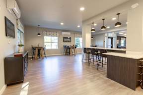 A modern kitchen and dining area with wooden floors and a large island.