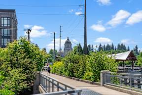 a man walking on a bridge with a view of the city
