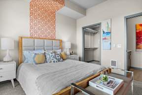 a bedroom with a large bed and a mirrored closet