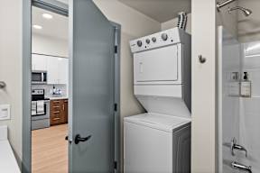 a laundry room with a washer and dryer and a door to a kitchen