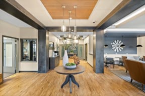 a living room with a wooden floor and a table with a vase on it