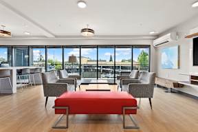 a conference room with couches and chairs and a red ottoman