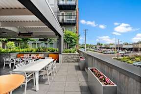 an outdoor patio with tables and chairs and a building in the background