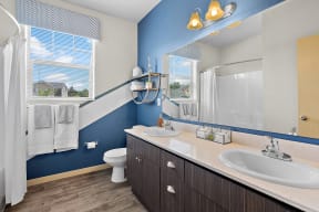 a bathroom with two sinks and a toilet and a shower