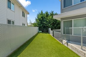 the backyard of a house with a green lawn and a fence