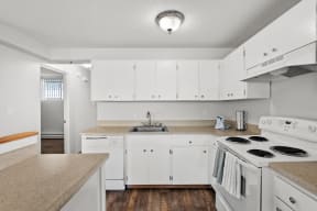 a kitchen with white appliances and counters and white cabinets