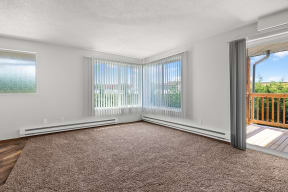 an empty living room with sliding glass doors and a carpet