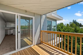 a deck with a view of a kitchen and trees