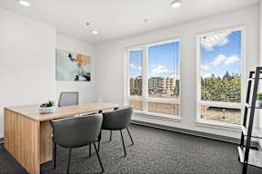 a meeting room with a wooden table and grey chairs
