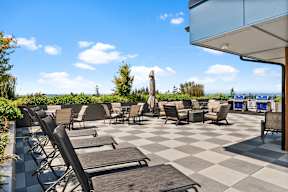 an outdoor patio with chairs and tables on a checkered tile floor