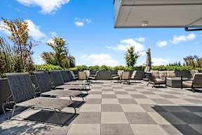 an outdoor patio with lounge chairs and umbrellas on a sunny day