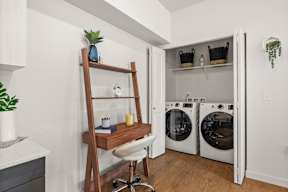 a small laundry room with a washer and dryer and a ladder in a at Telka Apartments, Washington