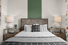 a bedroom with a bed and a green and white wall at Telka Apartments, Silverdale