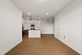 A kitchen with white cabinets and a wooden floor.