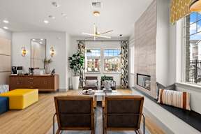 a living room with a table and chairs and a fireplace at Telka Apartments, Silverdale, Washington