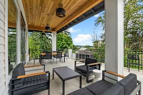 a covered patio with chairs and tables and a grill at Telka Apartments, Silverdale, WA, 98383