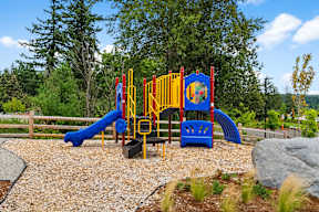 A playground with a blue slide and yellow and red play structure.