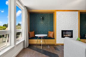 A living room with a fireplace and a table with two chairs.