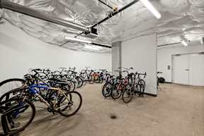 A room full of bicycles is covered with a white plastic sheet.