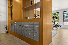 A room with a long wooden shelf and a row of mailboxes.