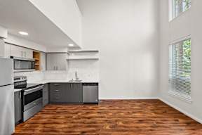 A kitchen with wooden floors and white walls.