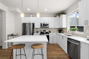 A modern kitchen with white cabinets and a large island.