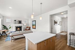 A modern kitchen with a white countertop and wooden cabinets.