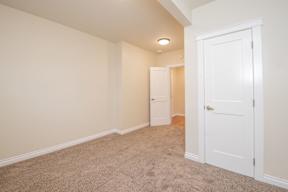 A room with a white door and carpeted floor.